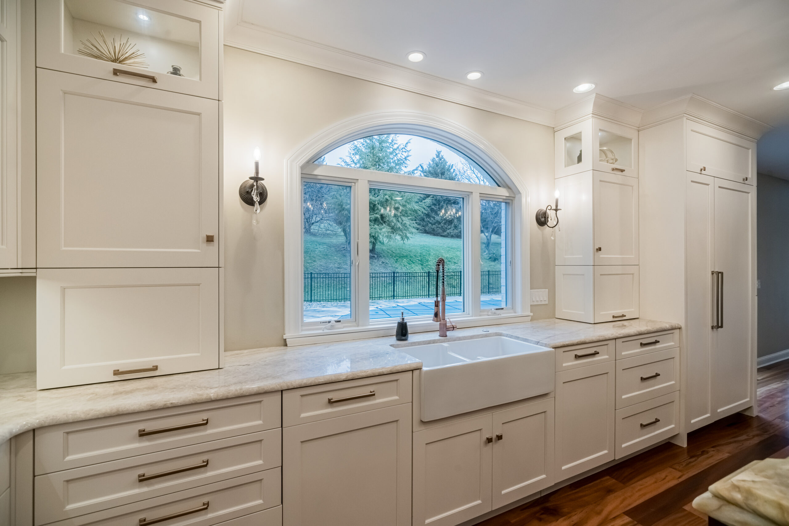 Kitchen: farmhouse sink under arched window, built by Premier Custom Builders